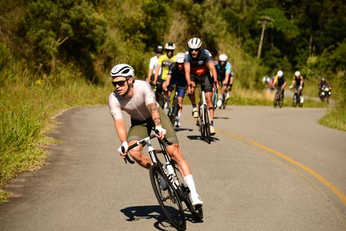 Free A group of cyclists racing intensely on a scenic, winding road during the day. Stock Photo
