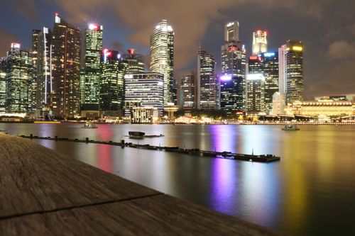 Free Beautiful night view of Singapore's illuminated skyline reflecting on Marina Bay waters. Stock Photo