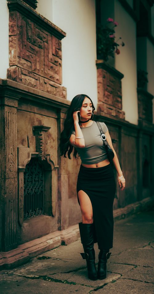 Free Fashionable woman in urban setting by rustic building, showcasing modern style and elegance. Stock Photo