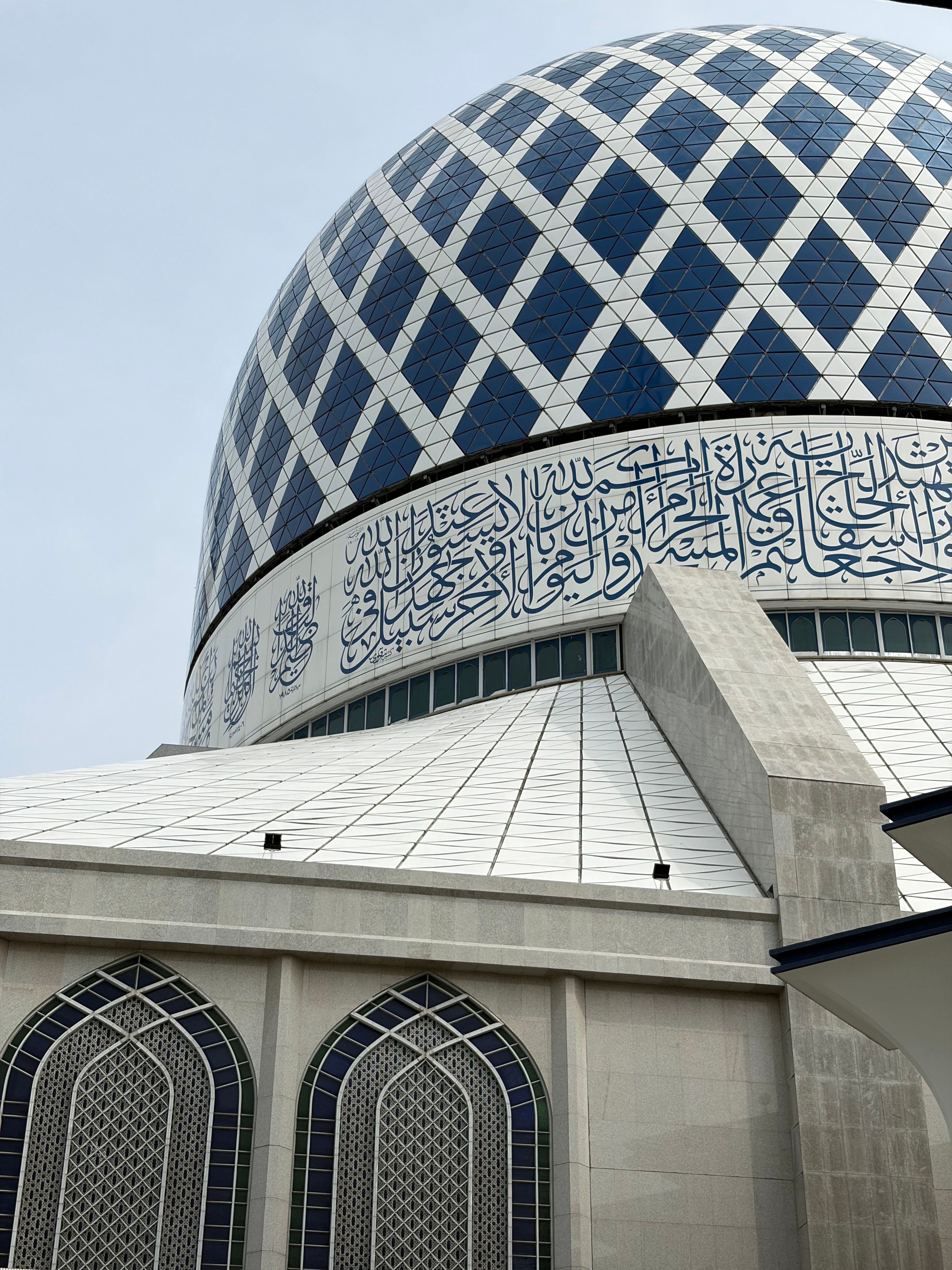Close-up of the Sultan Salahuddin Abdul Aziz Mosque dome featuring Islamic calligraphy.