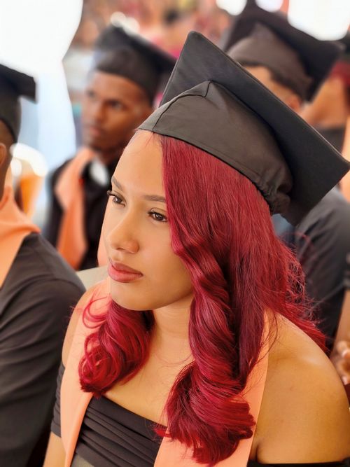 Free Female student with red hair in graduation attire during ceremony, wearing a cap and gown. Stock Photo