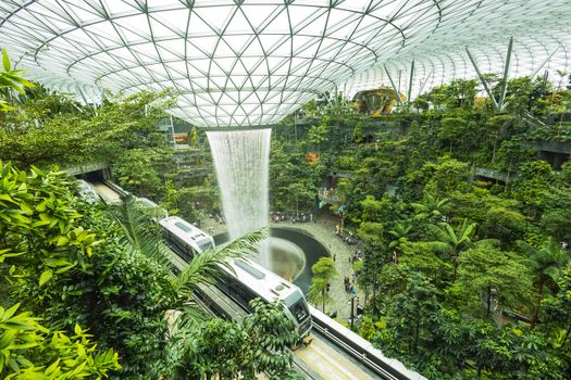 Breathtaking view of Jewel Changi's indoor waterfall surrounded by lush greenery and modern architecture.
