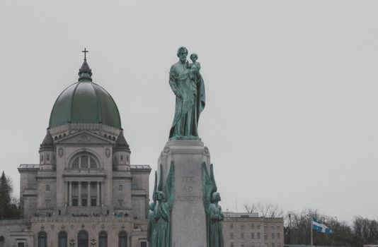 View of Saint Joseph's Oratory and statue in Montreal, Canada, on a cloudy day.
