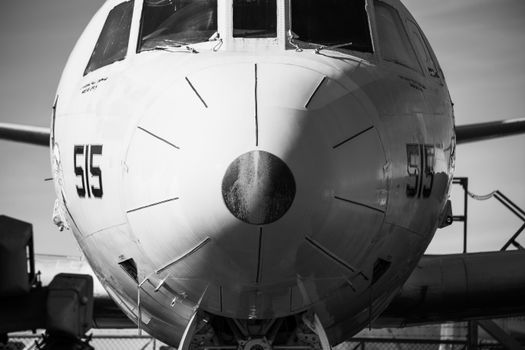Dramatic front view of a vintage airplane's nose captured in monochrome, highlighting its design and texture.