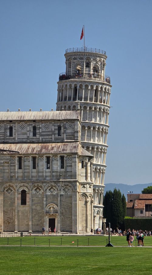Free Iconic Leaning Tower of Pisa with clear blue sky and tourists. Stock Photo