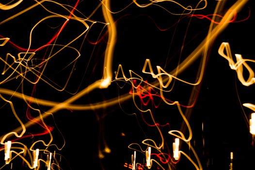 Engaging abstract image of vibrant light trails creating a dynamic pattern on a black background.