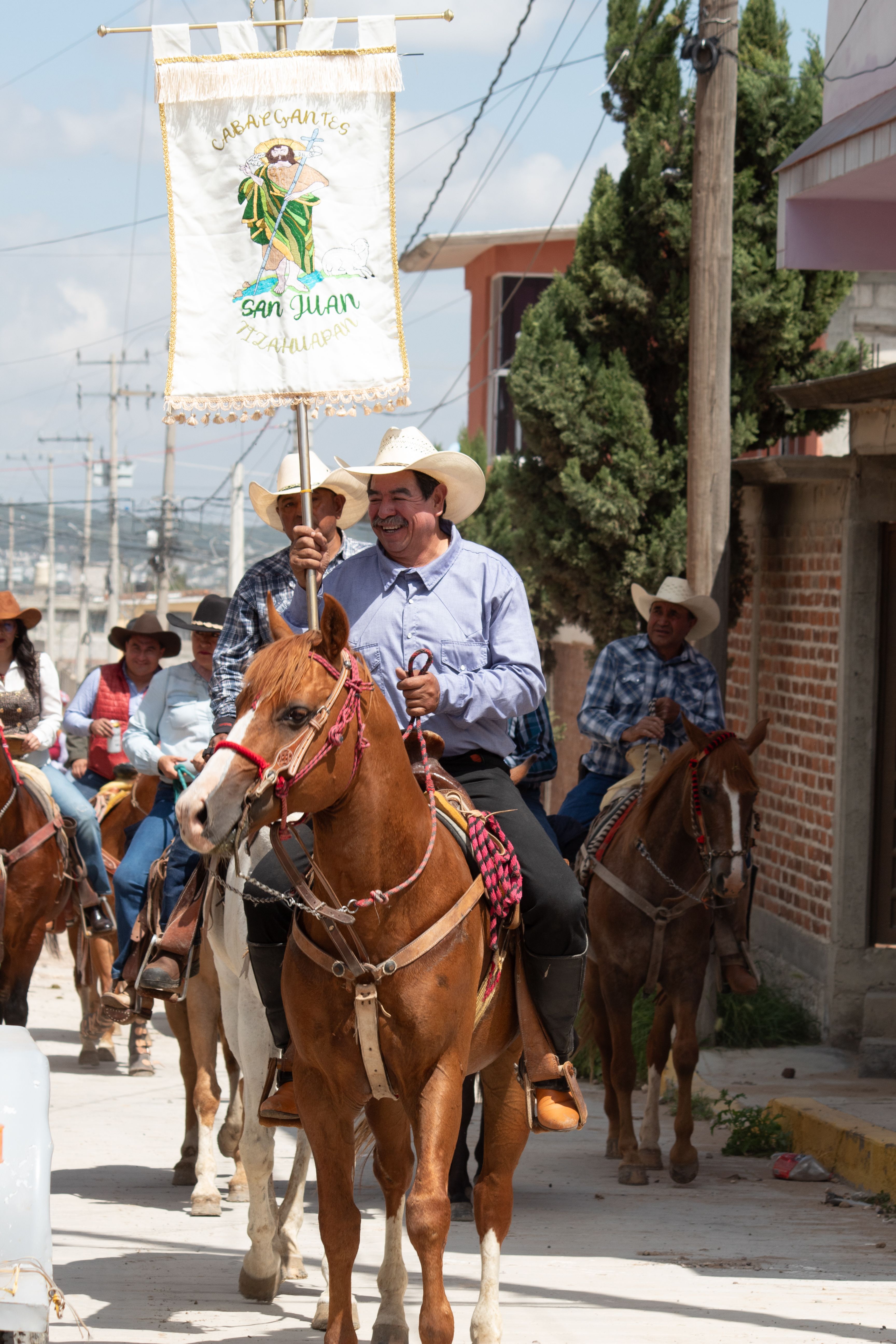 A vibrant parade showcasing riders on horseback, displaying a festive banner.