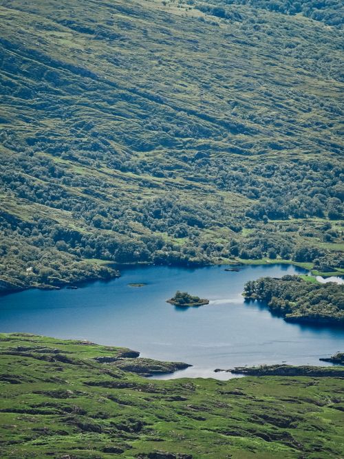 Free A tranquil aerial view of a blue lake nestled in Ireland's lush green countryside. Stock Photo