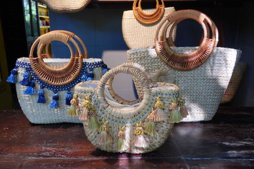 Free A collection of beautifully handcrafted straw baskets with detailed beadwork and tassels on display indoors. Stock Photo
