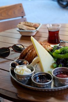 A classic Turkish breakfast setup with tea, cheese, olives, and bread outdoors in Istanbul.