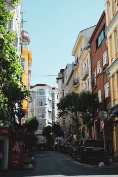 Colorful buildings line a quaint street in Istanbul, Turkey, under a clear blue sky.
