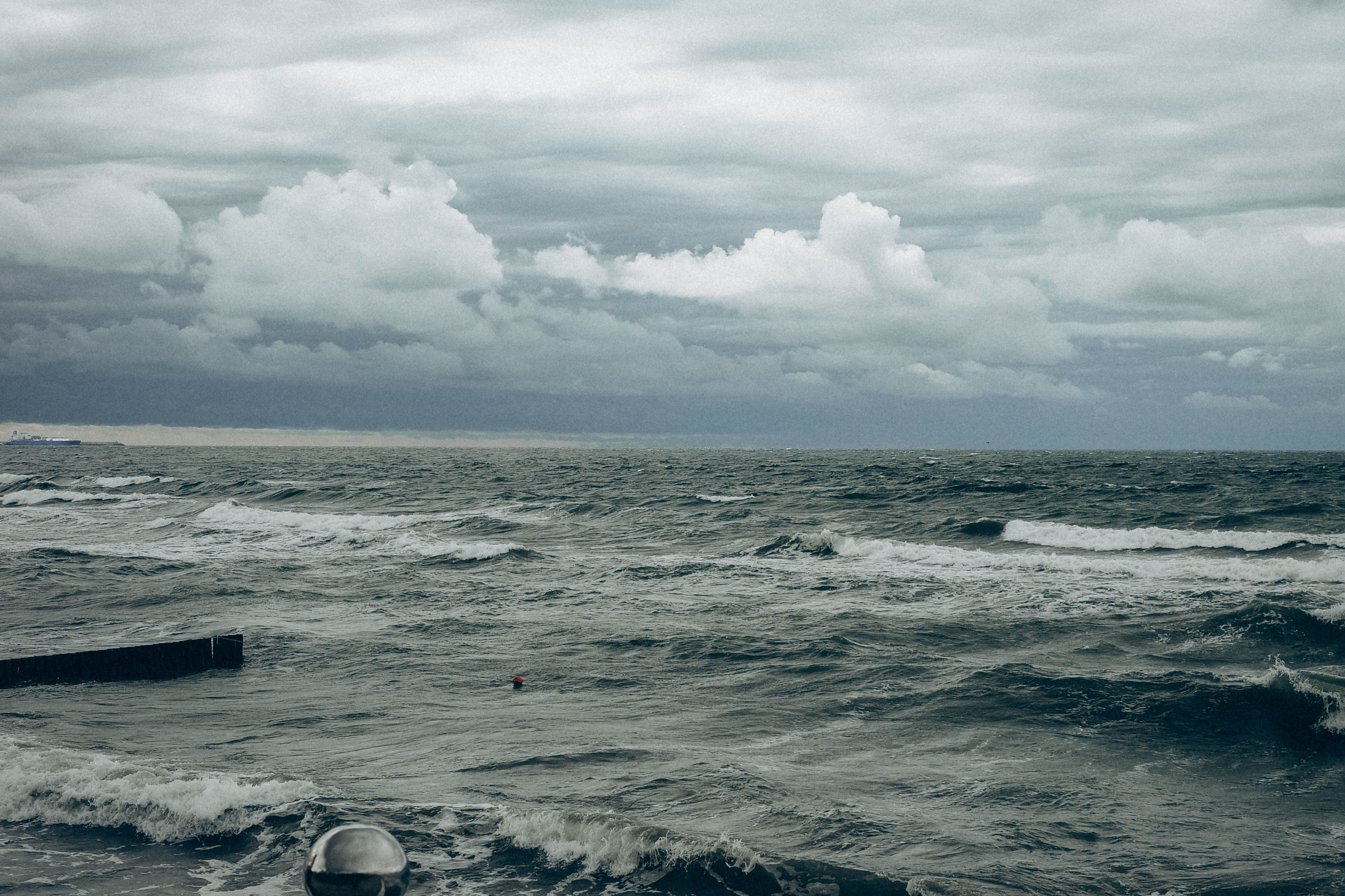 Grey stormy ocean waves breaking against a coastline