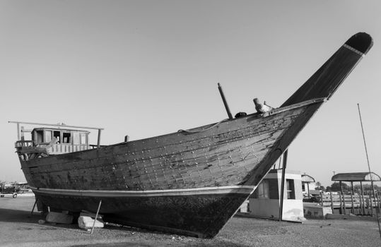 Black and white image of a traditional dhow boat exhibited in Doha, Qatar.