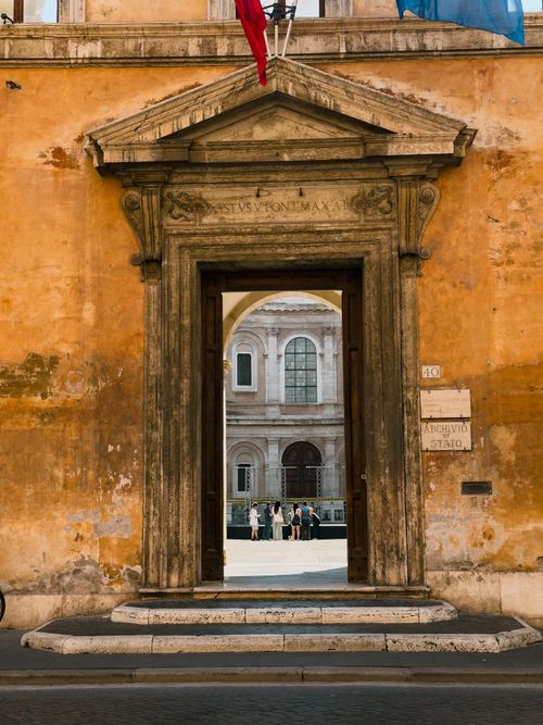 Free View through an ornate archway to an Italian piazza, capturing classic European architecture. Stock Photo
