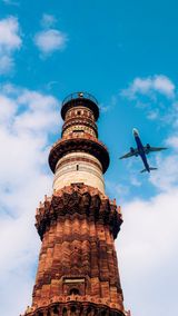Qutub Minar with an aircraft overhead