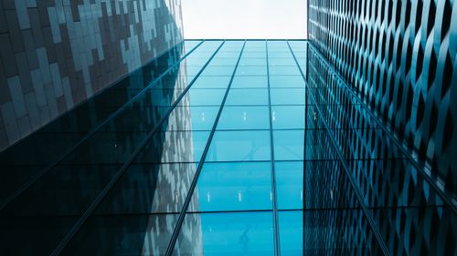 Free Dynamic perspective of towering modern glass and steel buildings under a clear sky. Stock Photo