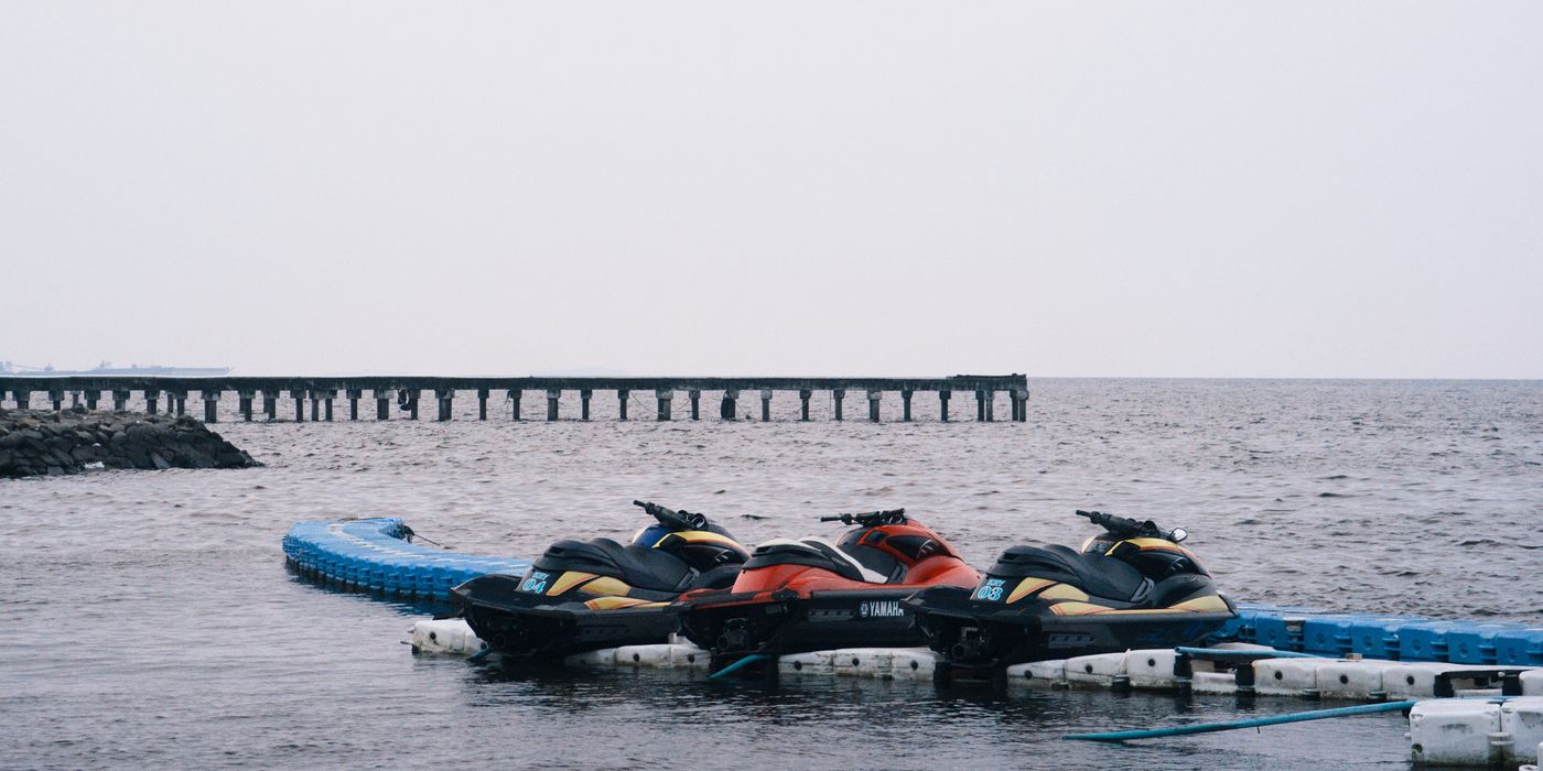 Jet skis tied up on a floating dock on a gray day