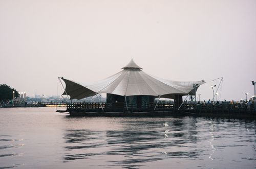 Free A tranquil tent pavilion by the waterfront, capturing a serene evening scene. Stock Photo