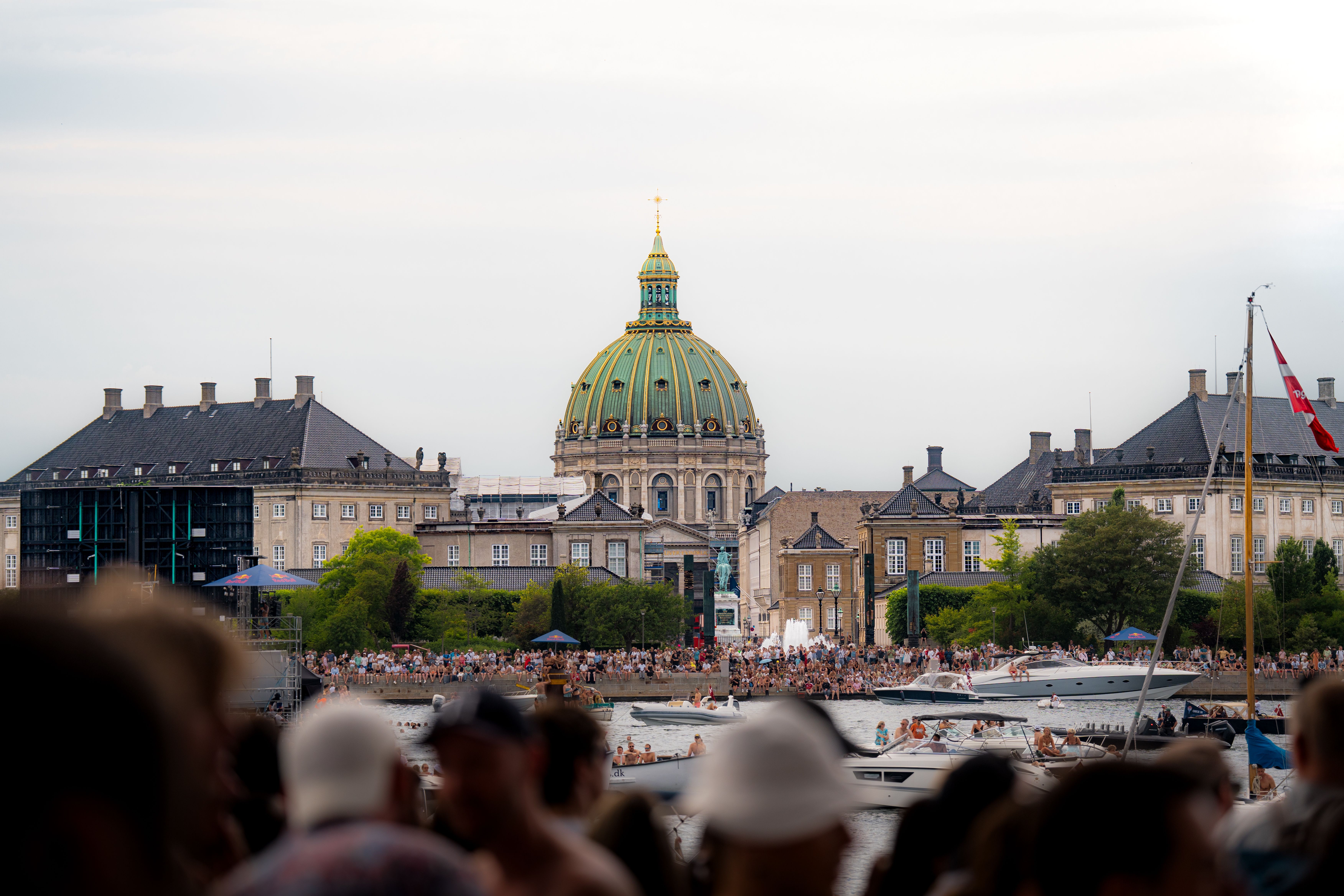 Vibrant summer scene at Frederiks Church in Copenhagen with people and boats on the water.