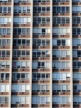 Close-up of an apartment building facade featuring repeating balconies and windows, creating a modern urban pattern.
