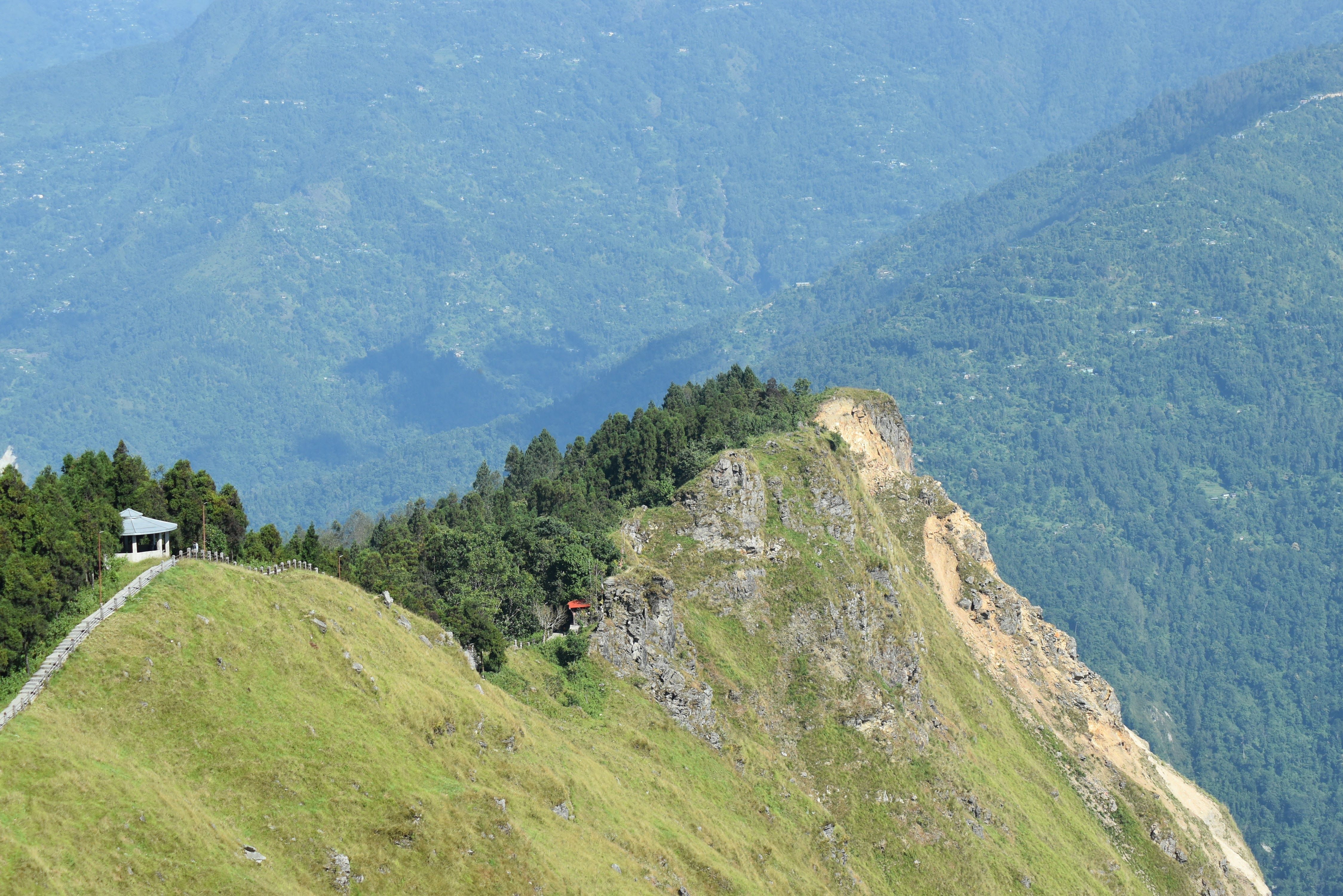 A beautiful mountain ridge with lush greenery and distant hills under a clear sky.