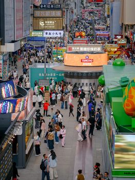 A lively street market filled with people shopping and vibrant signs, capturing urban energy.