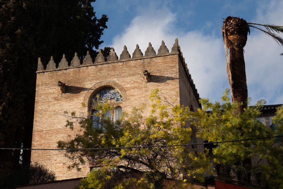 Una imagen cautivadora de un edificio histórico con fachada de ladrillo y características arquitectónicas únicas bajo un cielo brillante.