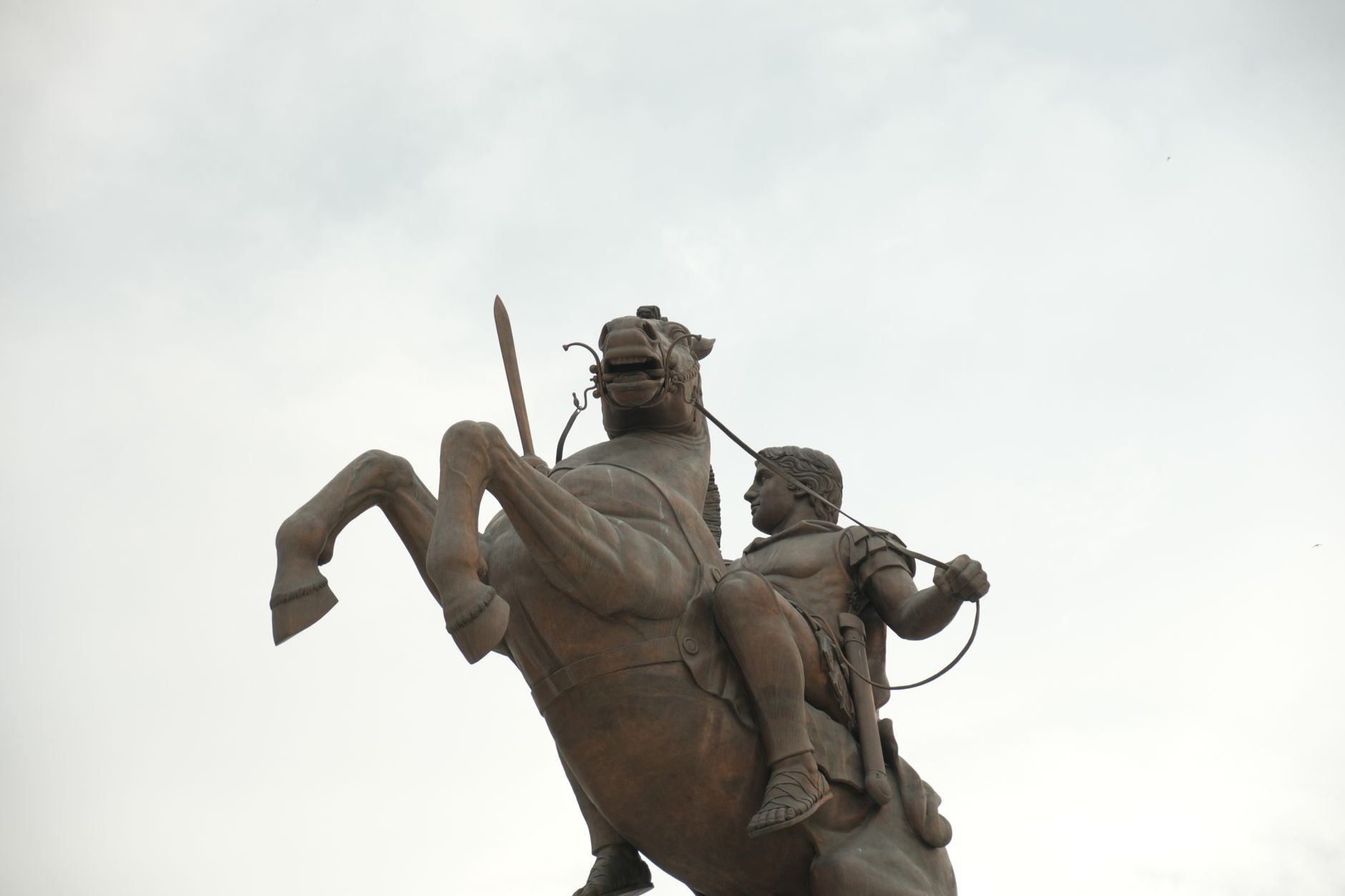 A striking equestrian statue silhouetted against a cloudy sky in Skopje, North Macedonia.