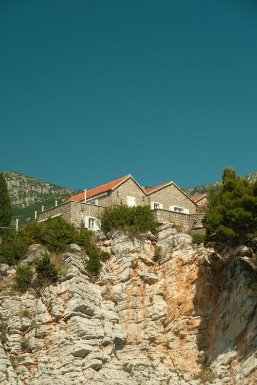 Free A charming stone house perched on a cliff with greenery in Budva, Montenegro. Stock Photo
