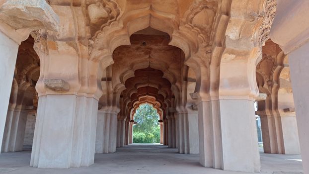 Explore the stunning arches of Lotus Mahal, a masterpiece of Indo-Islamic architecture in Hampi, India.