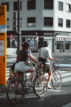 Cyclists wait at a crossing in Copenhagen, Denmark, during the day.
