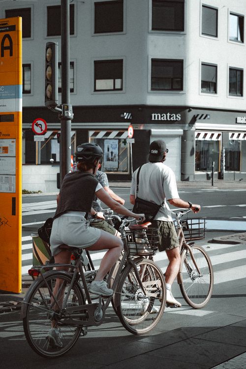 Free Cyclists wait at a crossing in Copenhagen, Denmark, during the day. Stock Photo