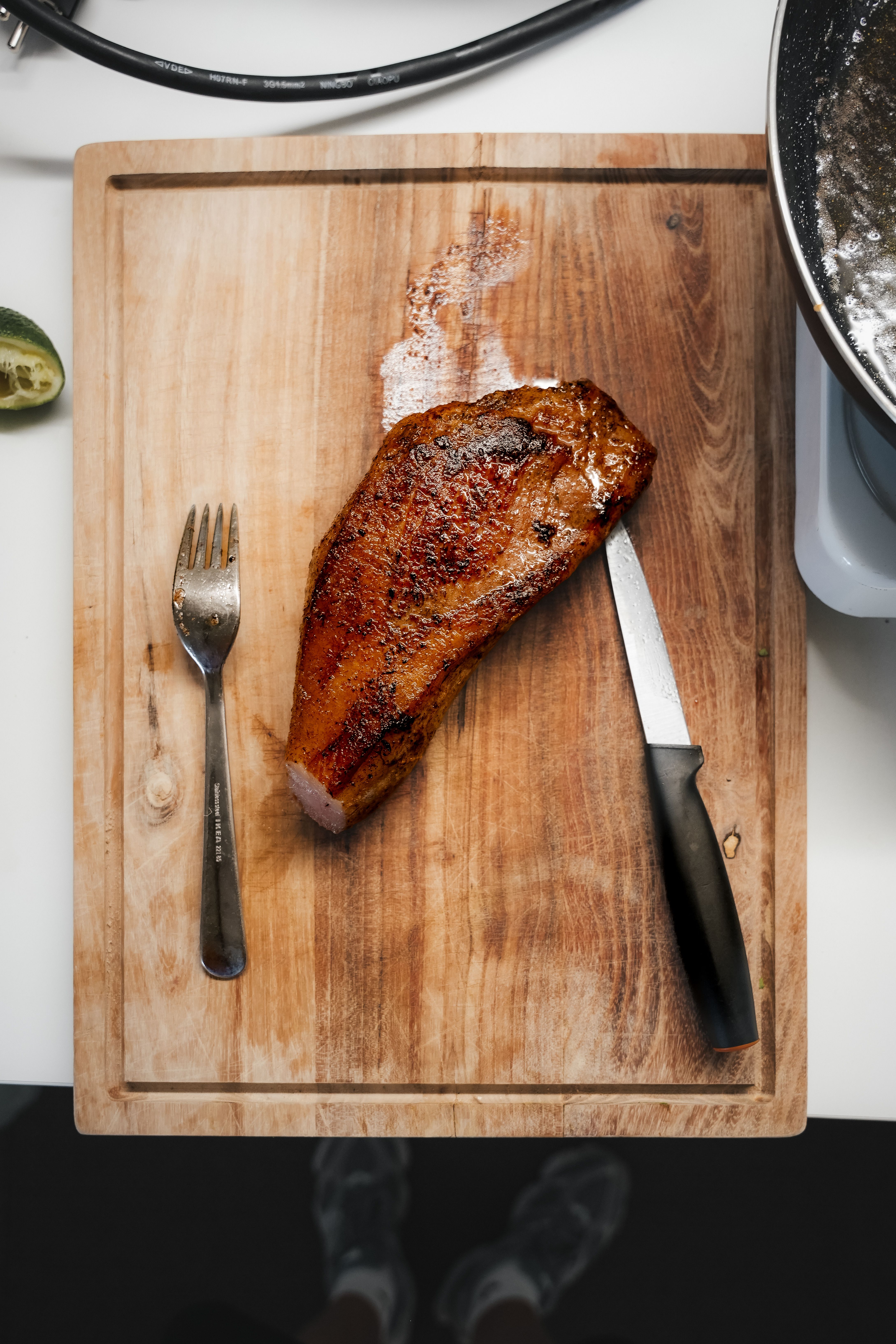 Deliciously seared pork resting on a rustic wooden cutting board. Perfect for food enthusiasts.