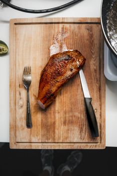 Deliciously seared pork resting on a rustic wooden cutting board. Perfect for food enthusiasts.