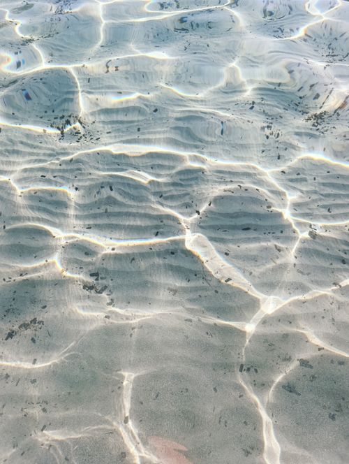 Free Sunlight creates mesmerizing ripple patterns on clear shallow water, evoking tranquility. Stock Photo