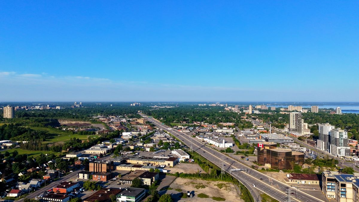 Aerial view of a growing city with a major highway and green space