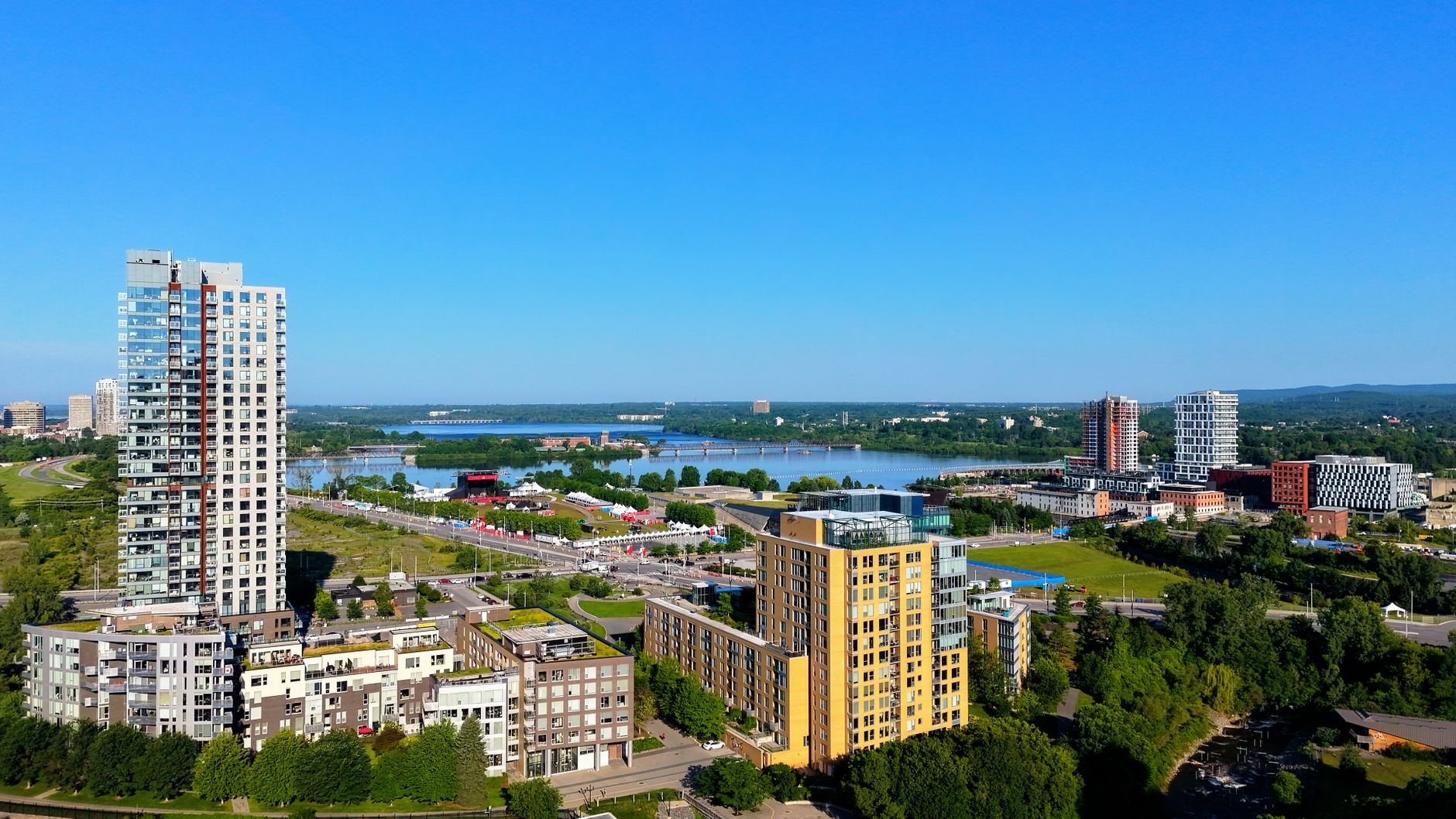 Aerial view capturing urban skyline with modern buildings alongside a serene river.