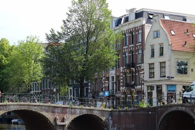 Historic brick houses beside a Dutch canal bridge, photo by Catarina Duarte on Pexels