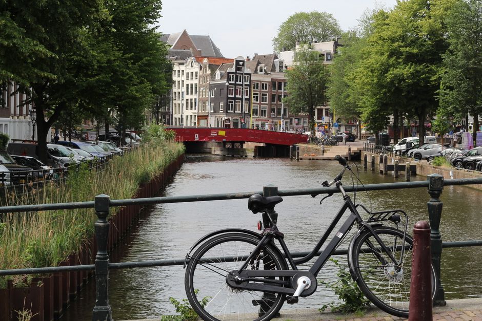 Charming canal and bicycle in Amsterdam, showcasing historic architecture and vibrant urban lifestyle.