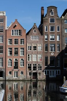 Traditional canal houses with picturesque reflections in Amsterdam.