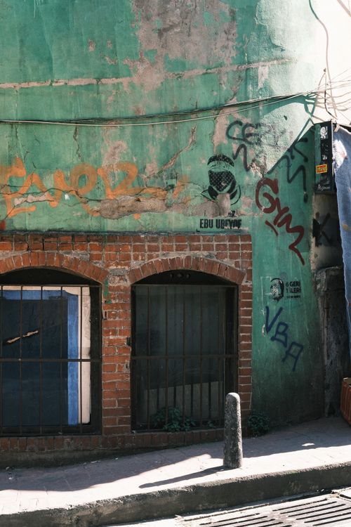 Free Vibrant graffiti art on a rustic brick wall in a sunlit city alley. Stock Photo