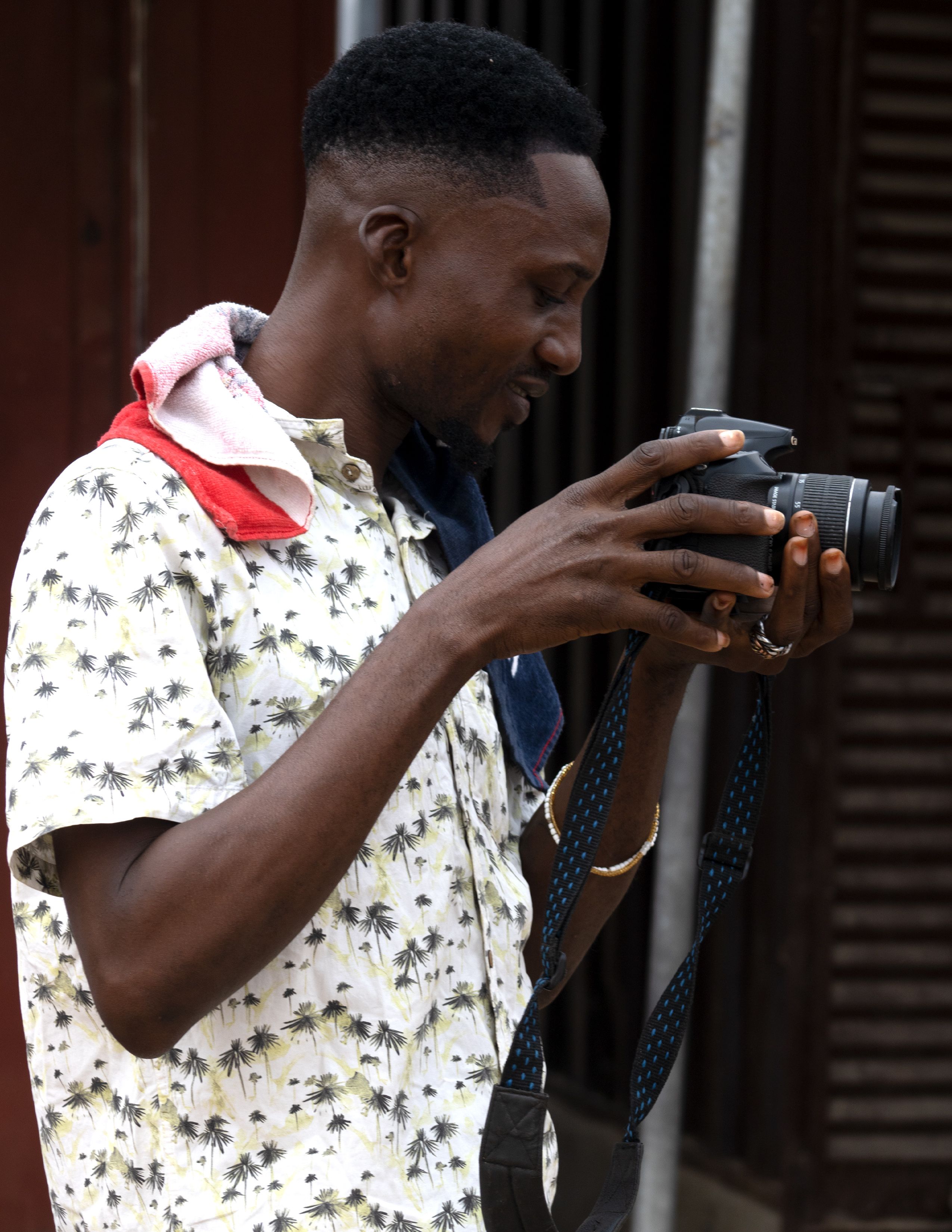A photographer examines camera settings, capturing a candid moment outdoors.