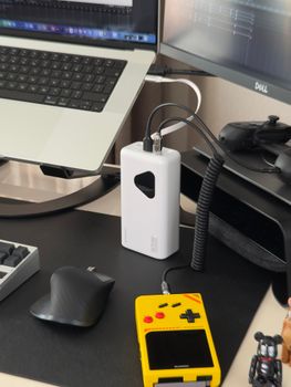 A contemporary desk setup featuring a laptop, power bank, and tech gadgets for an organized workspace.