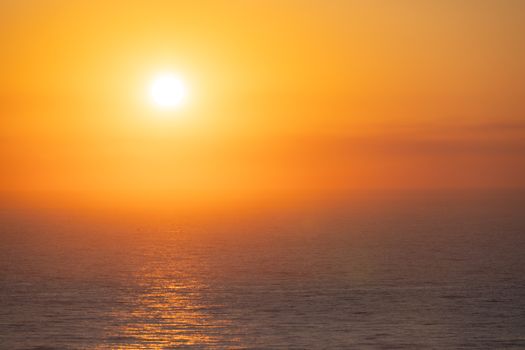A mesmerizing sunset over the ocean with golden hues reflecting on the water.
