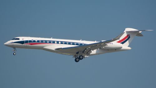 Free A private jet flying against a bright blue sky, showcasing elegance and speed. Stock Photo