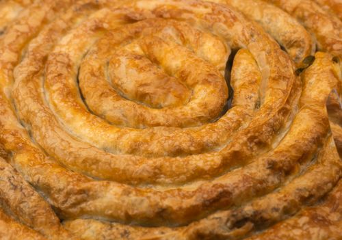 Free Golden brown spiral-shaped Turkish borek with flaky pastry texture, capturing delicious savory detail. Stock Photo