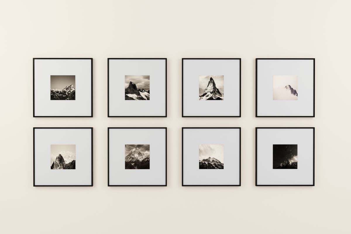 Two framed landscape photographs hanging in a row on a plain wall