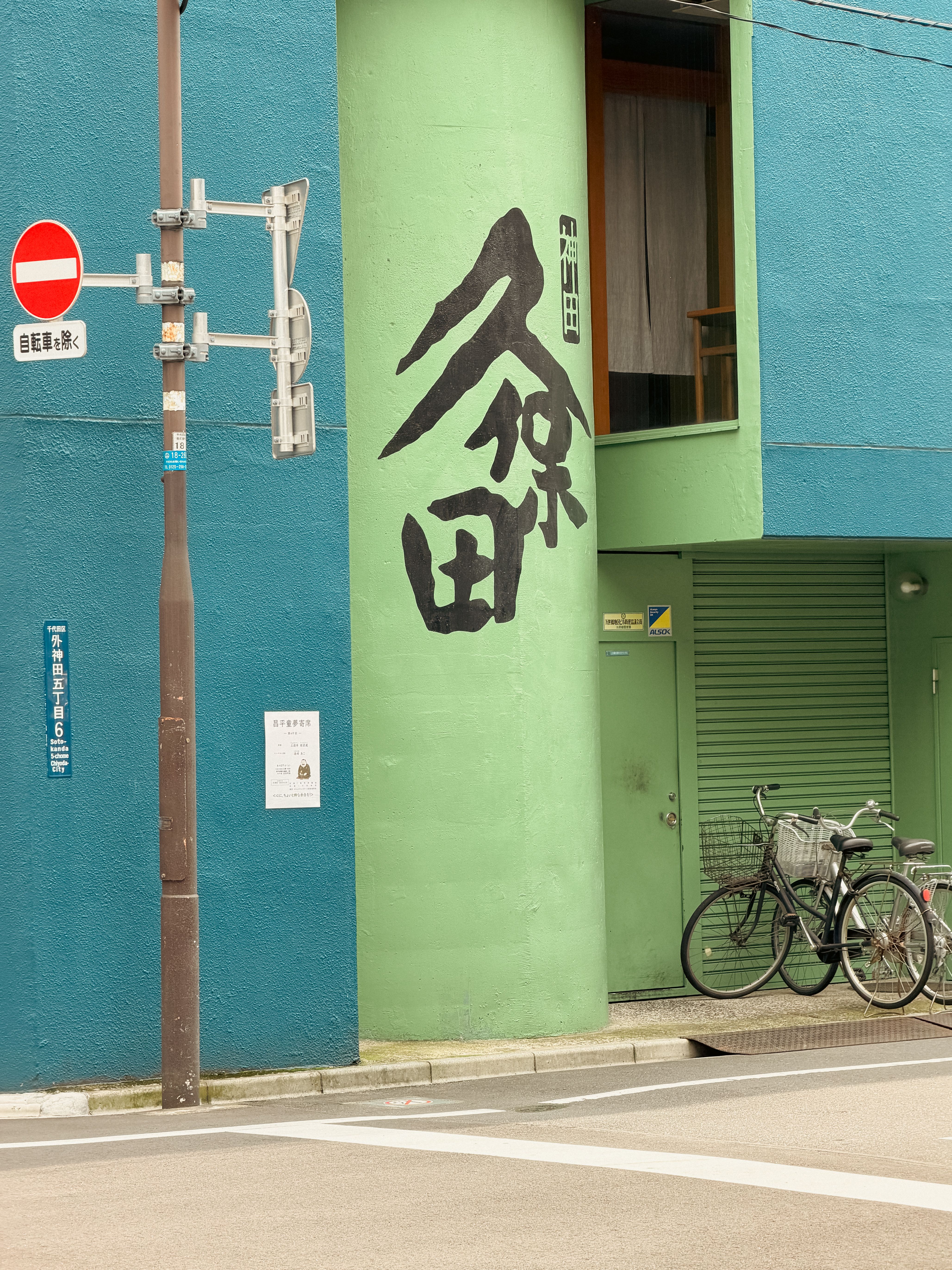 Vibrant street scene in Tokyo featuring bicycles and Japanese signage against colorful buildings.