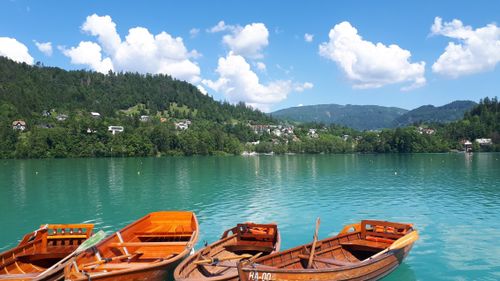 Free Tranquil lake scene with wooden boats and mountainous backdrop under blue skies. Stock Photo