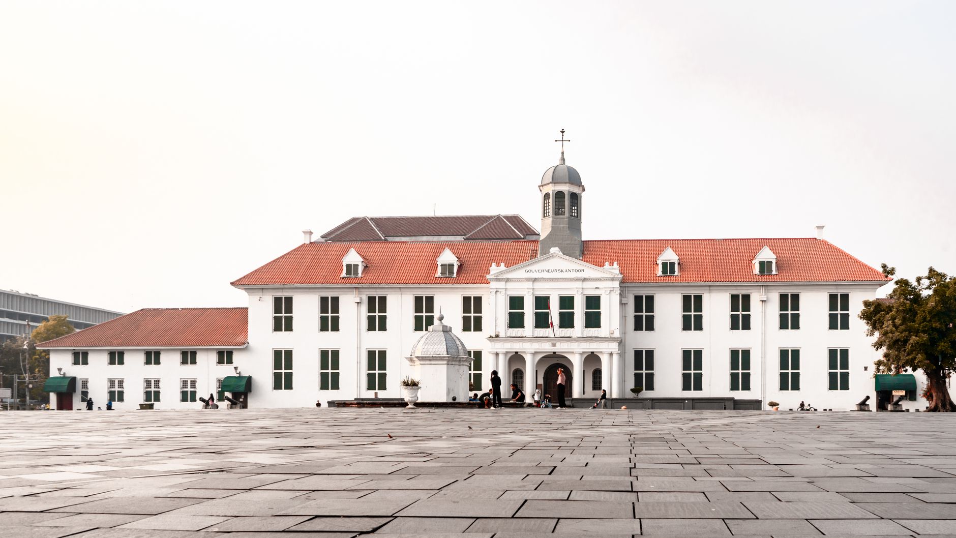 Fatahillah Square in Jakarta featuring a historic colonial-era building with red-tiled roofs and a central tower.